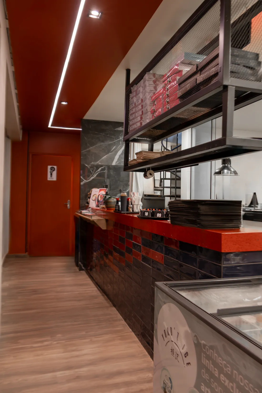Balcão de atendimento e corredor interno do restaurante Donburi, com a cozinha ao fundo